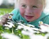 Girl in meadow holding daisies