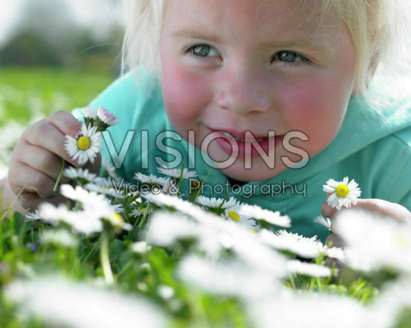 Girl in meadow holding daisies