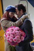Man welcomes woman with flowers