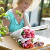 Woman with bunch of tulips on garden table