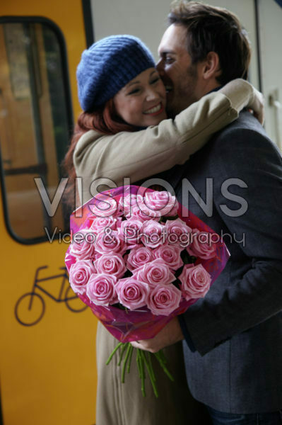 Man verwelkomd vrouw met bloemen