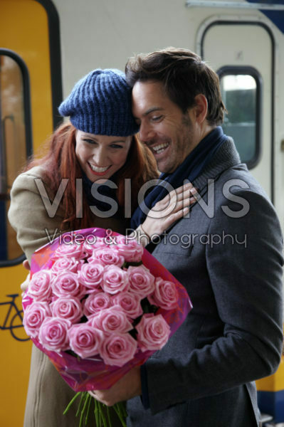 Man welcomes woman with flowers