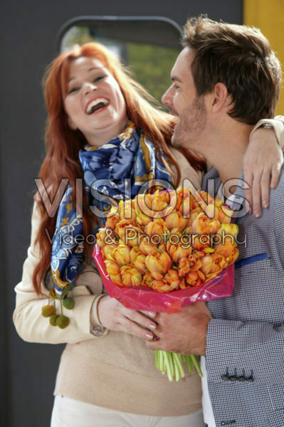 Man verwelkomd vrouw met bloemen