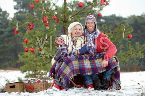 Couple sitting under christmas tree