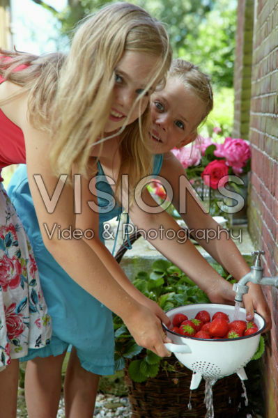Girls washing strawberries
