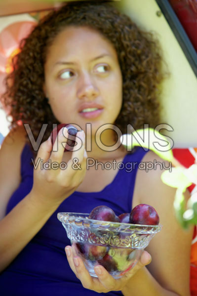 Girl eating plum
