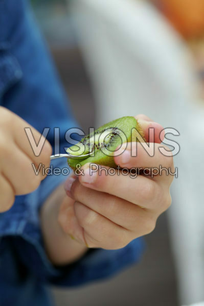 Child eating kiwi fruit