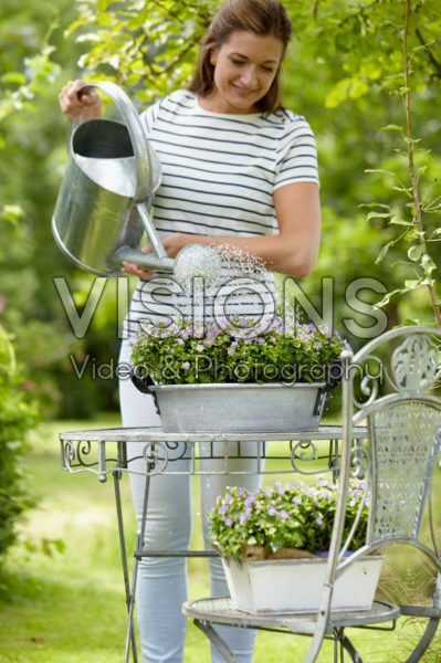 Dame geeft planten water