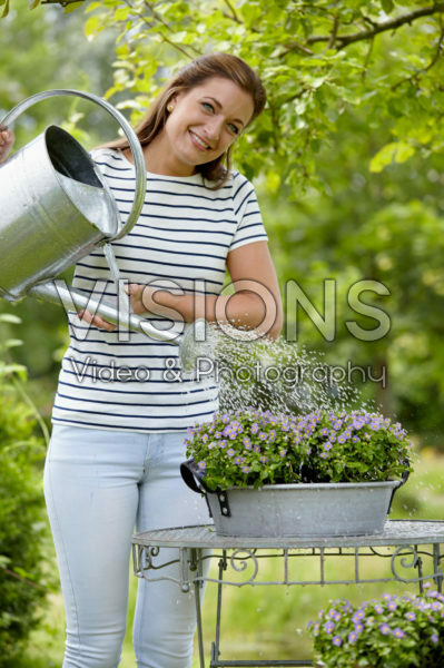 Dame geeft planten water