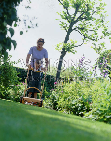 Mother and son mowing lawn