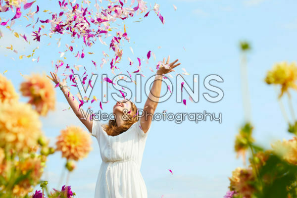Lady throwing dahlia petals