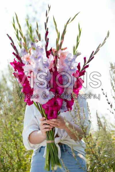 Lady holding bunch of gladioli