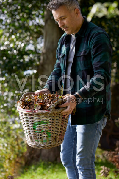Man holding basket with autumn leaves