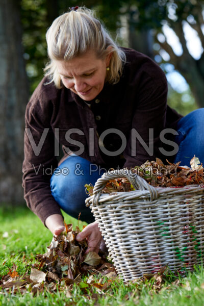 Woman collecting fallen leaves