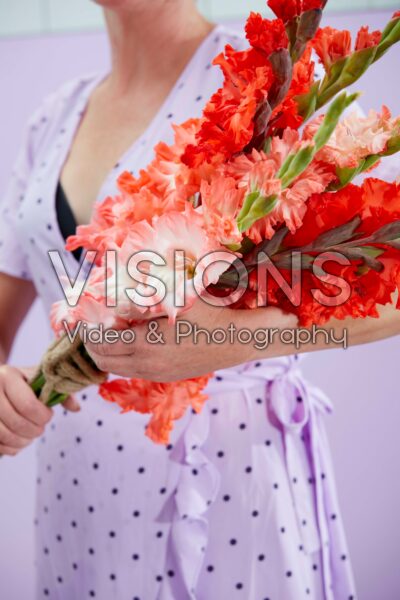 Lady holding mixed bunch of Flamencos gladioli