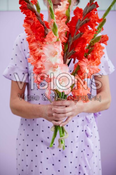 Lady holding mixed bunch of Flamencos gladioli