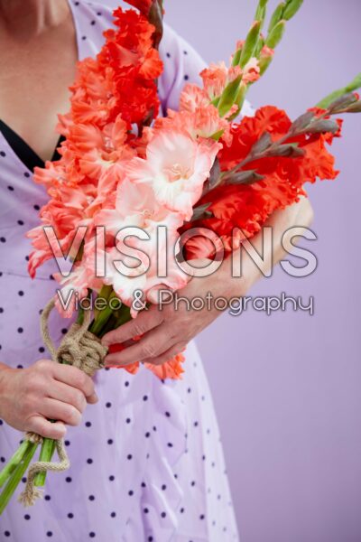 Lady holding mixed bunch of Flamencos gladioli