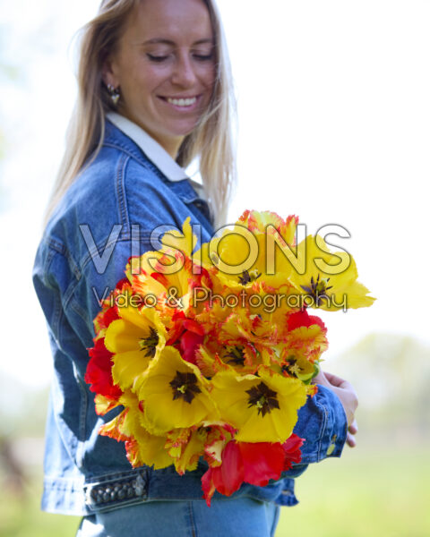Dame met gemengd tulpenboeket rood en geel Dame met gemengd tulpenboeket rood en geel