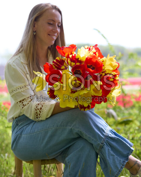 Dame met gemengd tulpenboeket rood en geel Dame met gemengd tulpenboeket rood en geel
