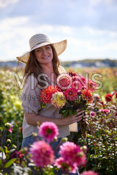 Lady with mixed bouquet in dahlia garden