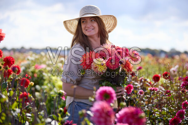 Dame met gemengd boeket in dahliatuin