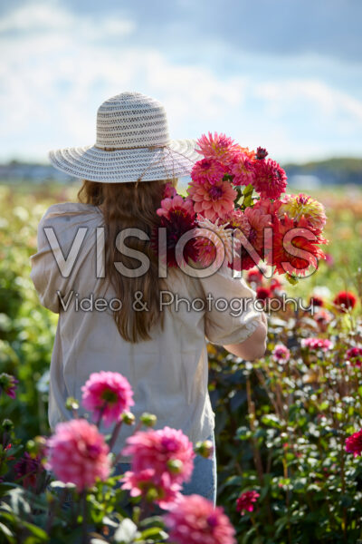 Dame met gemengd boeket in dahliatuin Dame met gemengd boeket in dahliatuin