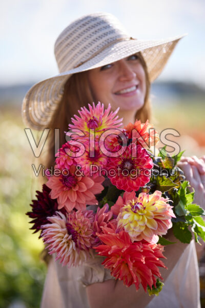 Lady with mixed bouquet in dahlia garden