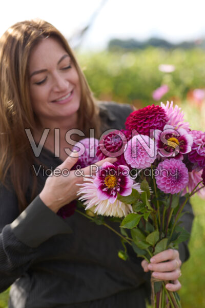 Dame met gemengd dahliaboeket