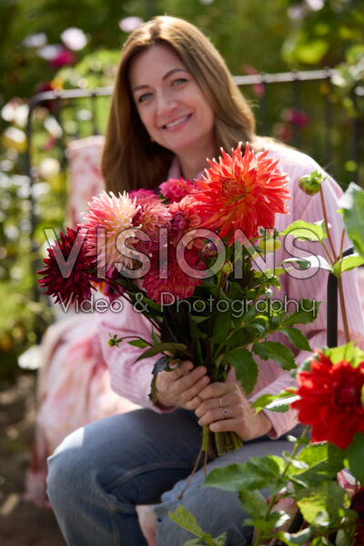 Dame met gemengd dahliaboeket