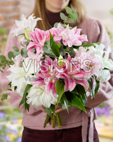 Dame met gemengd lelieboeket