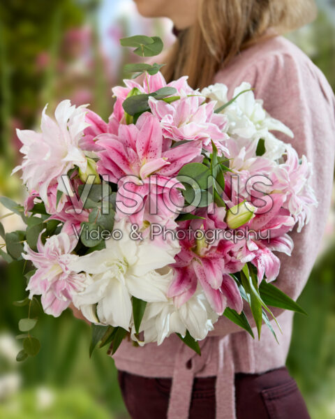 Dame met gemengd lelieboeket