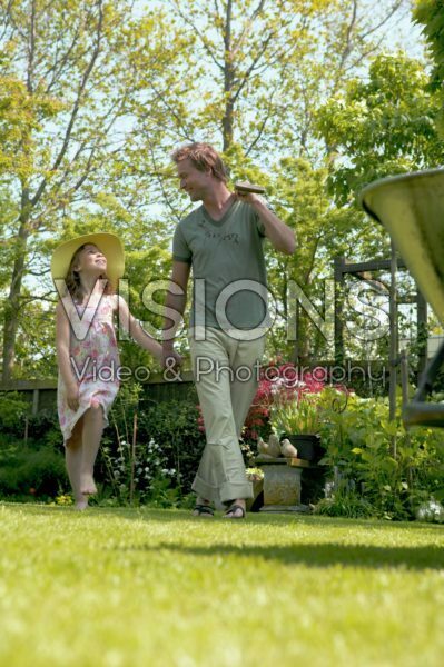 Father and daughter walking through yard