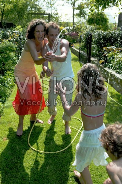 Children and parents playing with water in the garden