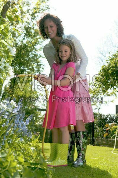 Mother and daughter with hose