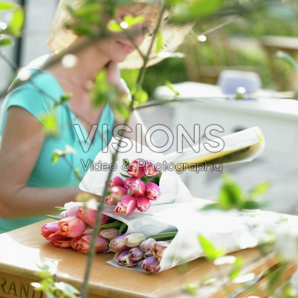 Woman with bunch of tulips on garden table