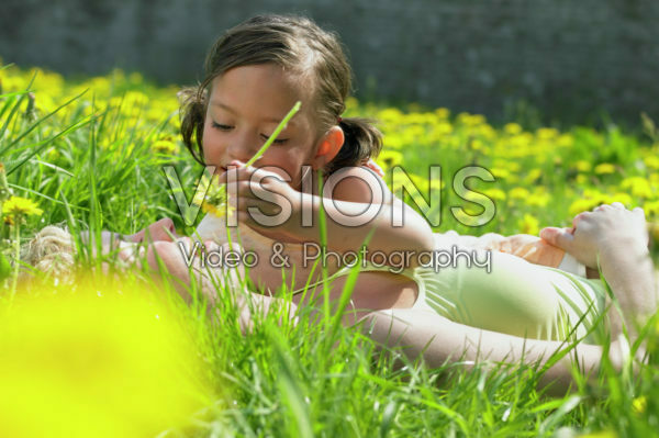 Mother and daughter lying in grass