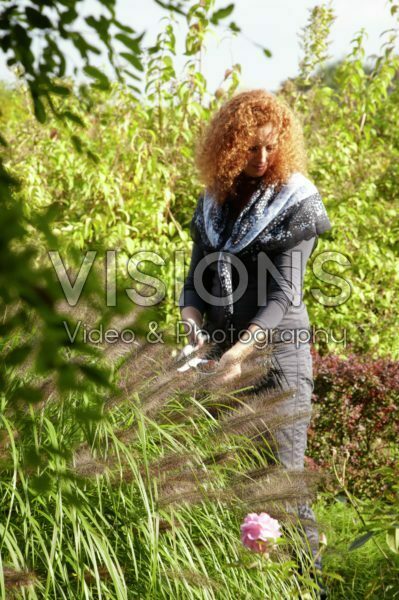 Woman trimming ornamental grass